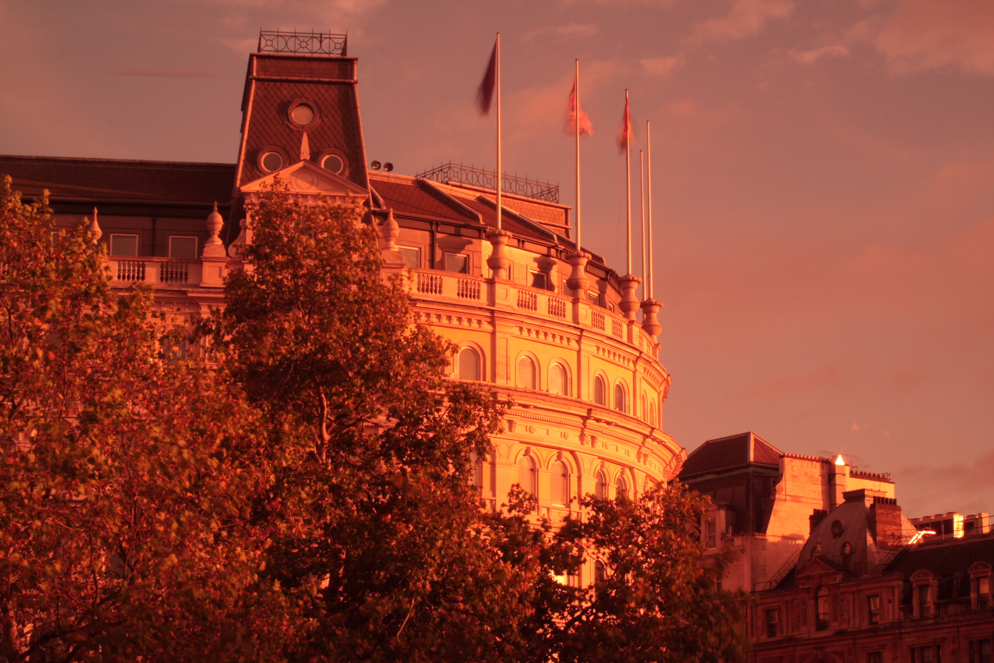 Sunset reflecting off of a building in Trafalgar Square - note I was using a red filter when taking this photo which explains the intensity of the light